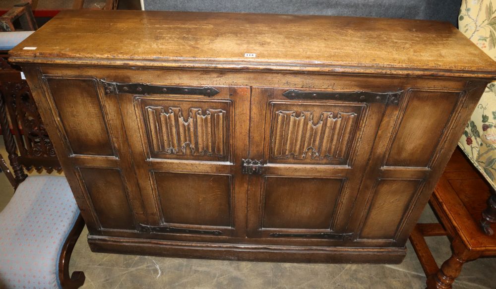 An 18th century style linen fold moulded oak two door cabinet, W.150cm, D.39cm, H.107cm